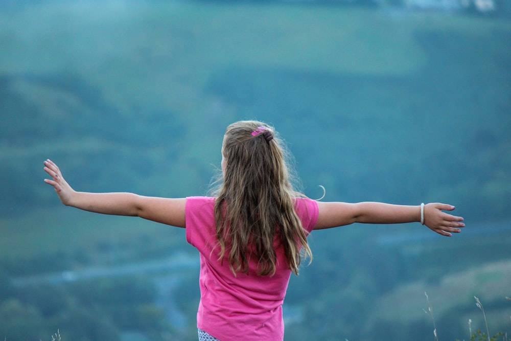 girl in pink t-shirt and pink shorts holding her hair