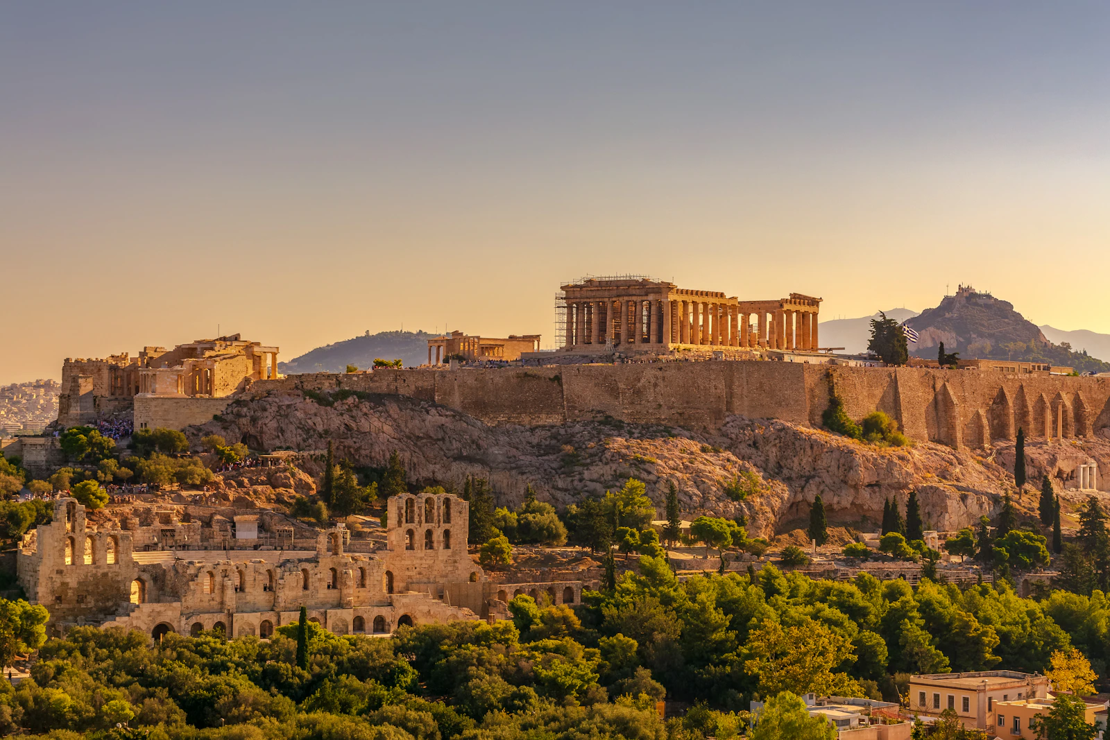 Athens rooftops and streets viewed from above with the Acropolis in the background
