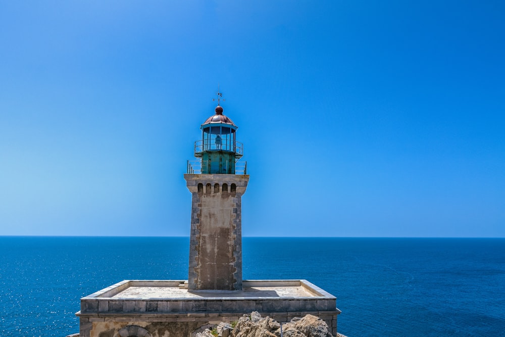 brown and white concrete lighthouse near sea during daytime