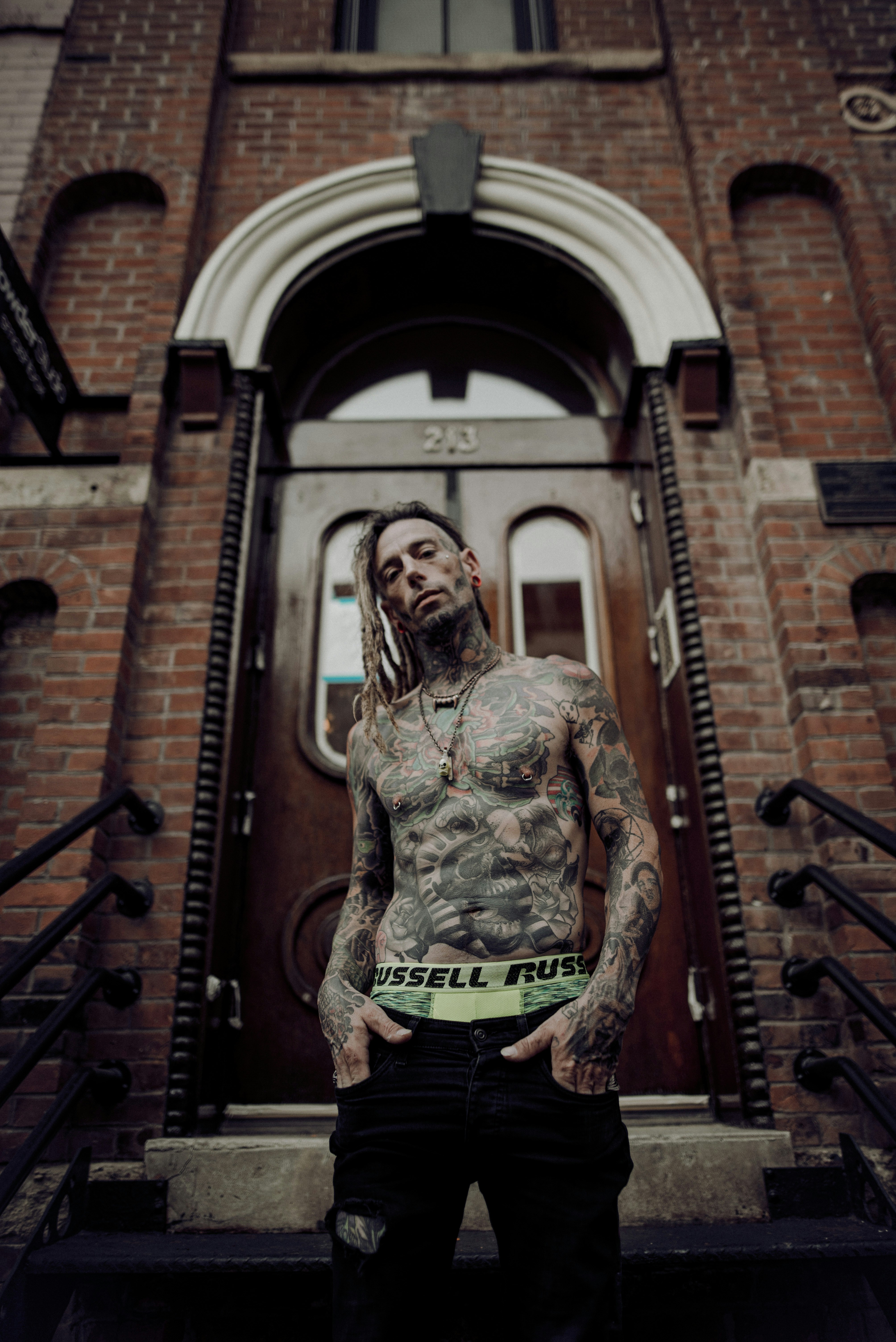 woman in brown and black camouflage jacket and black pants standing on brown wooden staircase