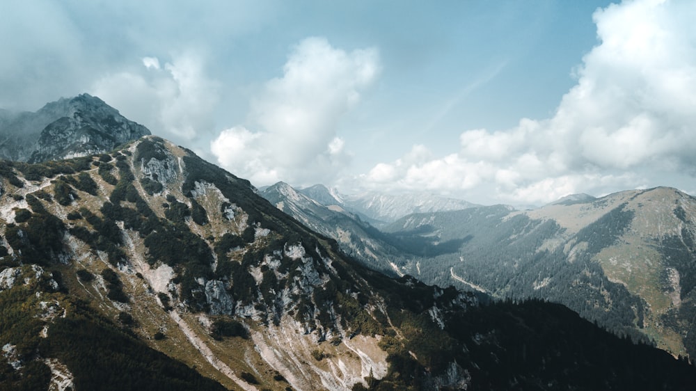 green and brown mountains under white clouds and blue sky during daytime