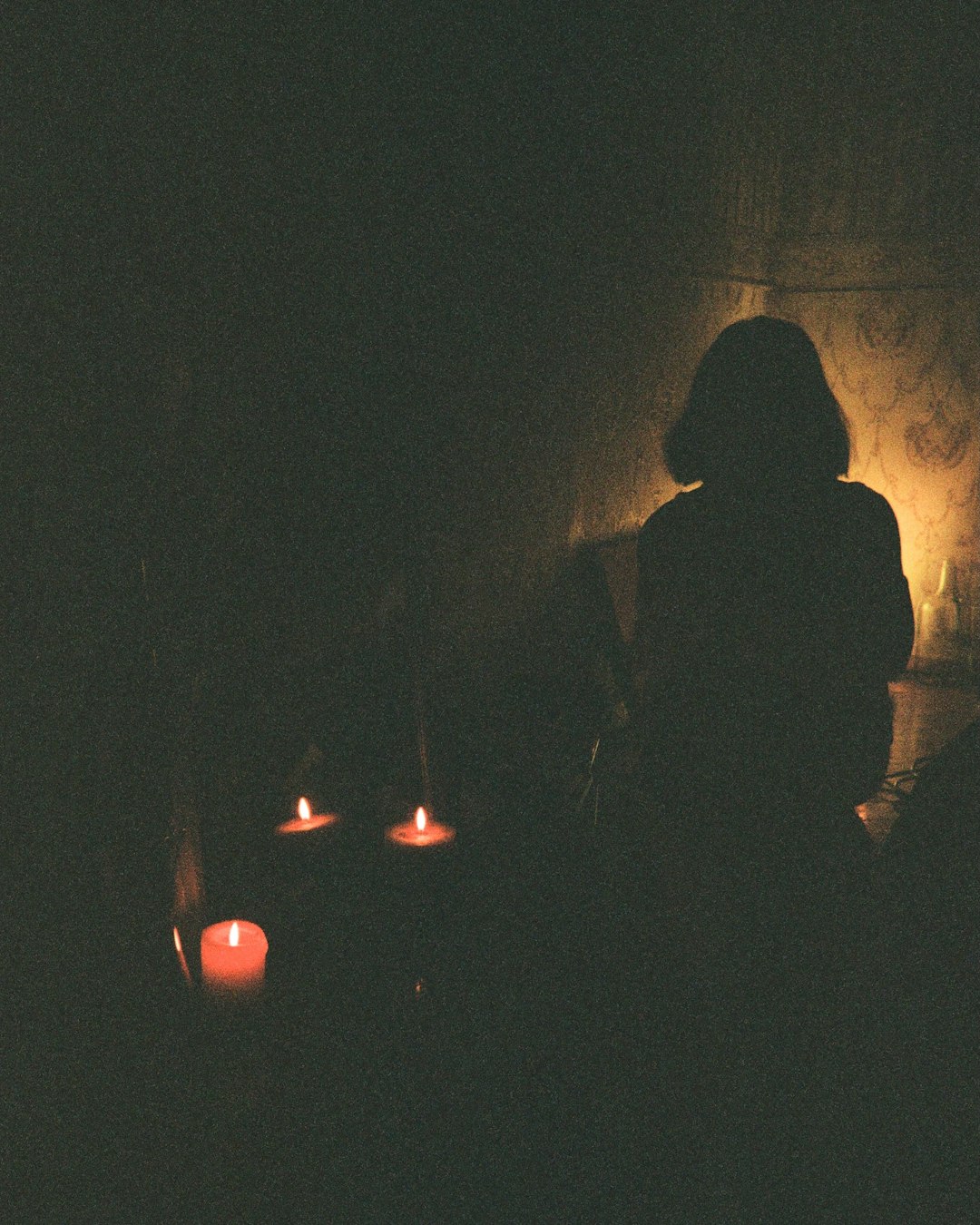 silhouette of man and woman standing in front of lighted candles