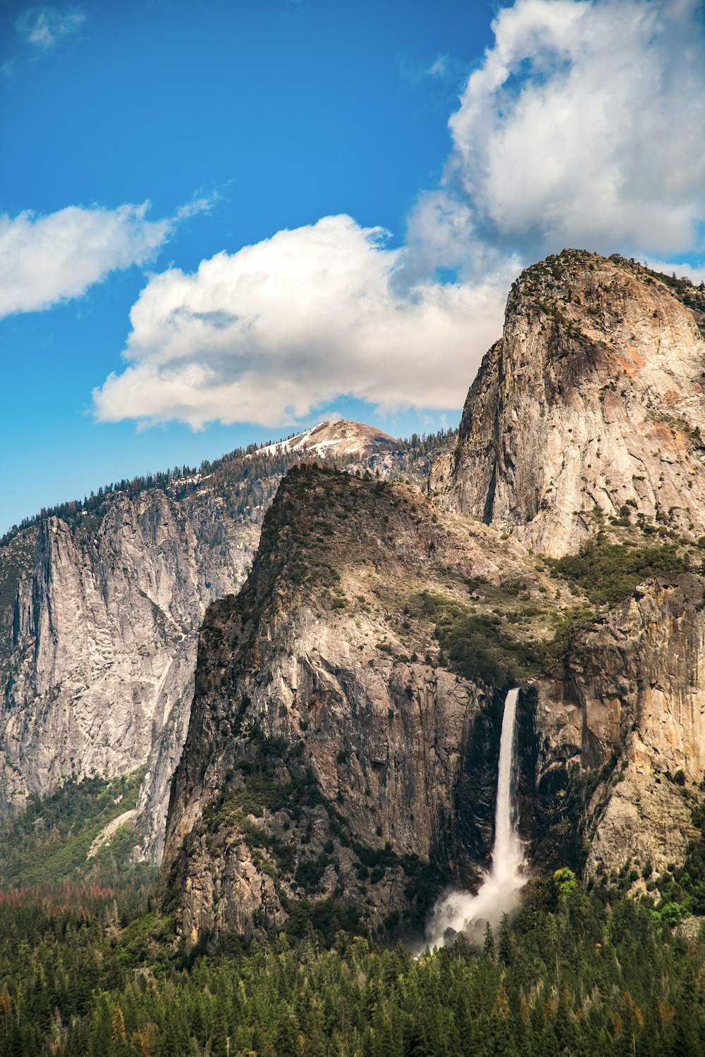 waterfalls on rocky mountain under blue sky during daytime