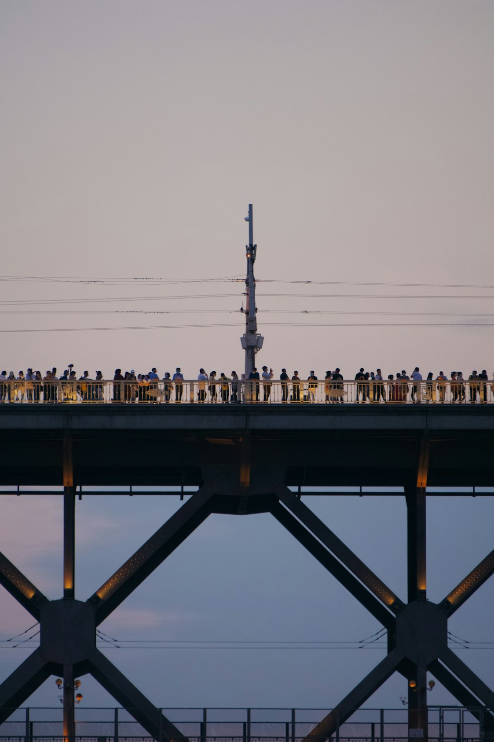 um grupo de pessoas em pé no topo de uma ponte