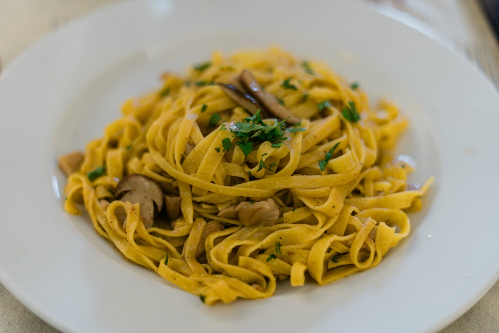 plat de pâtes sur assiette en céramique blanche