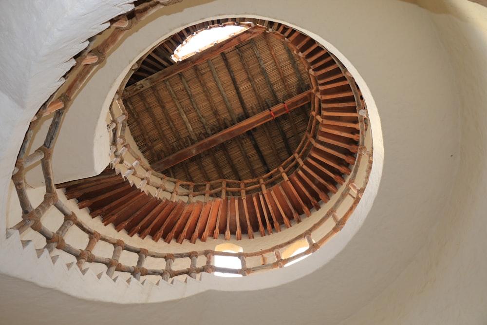 brown wooden spiral staircase on white painted wall