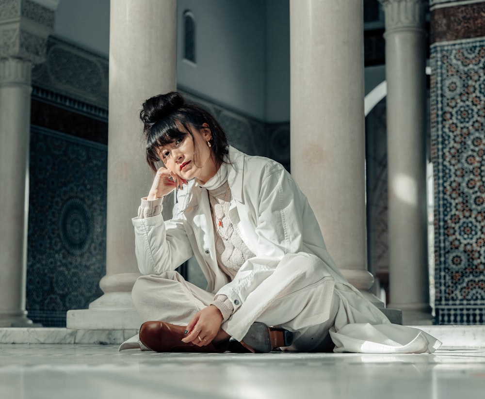 woman in white robe sitting on floor