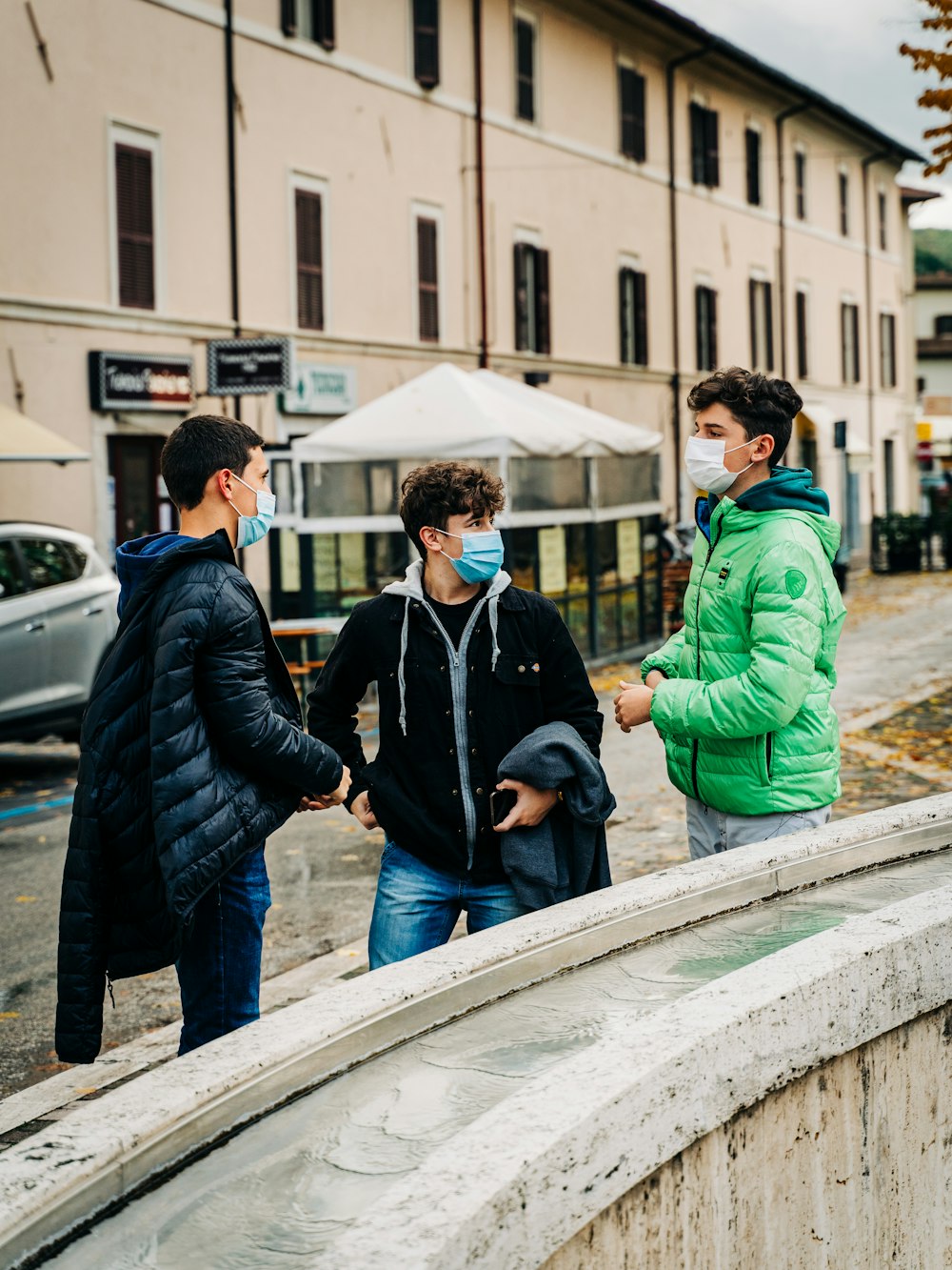 man in black jacket standing beside woman in green jacket