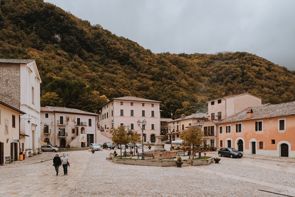 two people walking down a cobblestone street