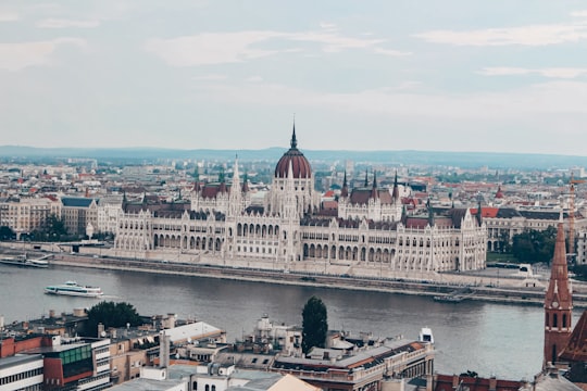 white and brown concrete building near body of water during daytime in Fisherman's Bastion Hungary