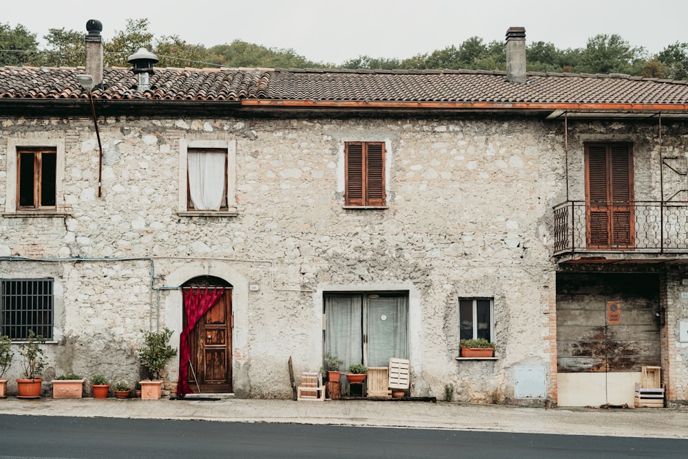 red trash bin beside white concrete building