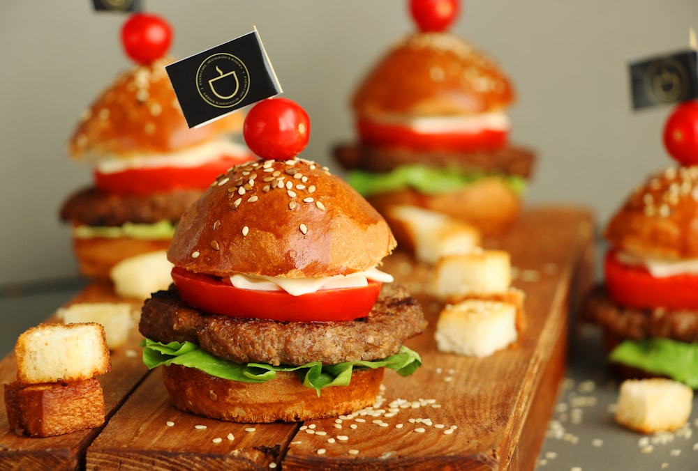 burger with lettuce and tomato on brown wooden tray