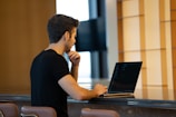 A man working intently on his laptop in a cozy home office.