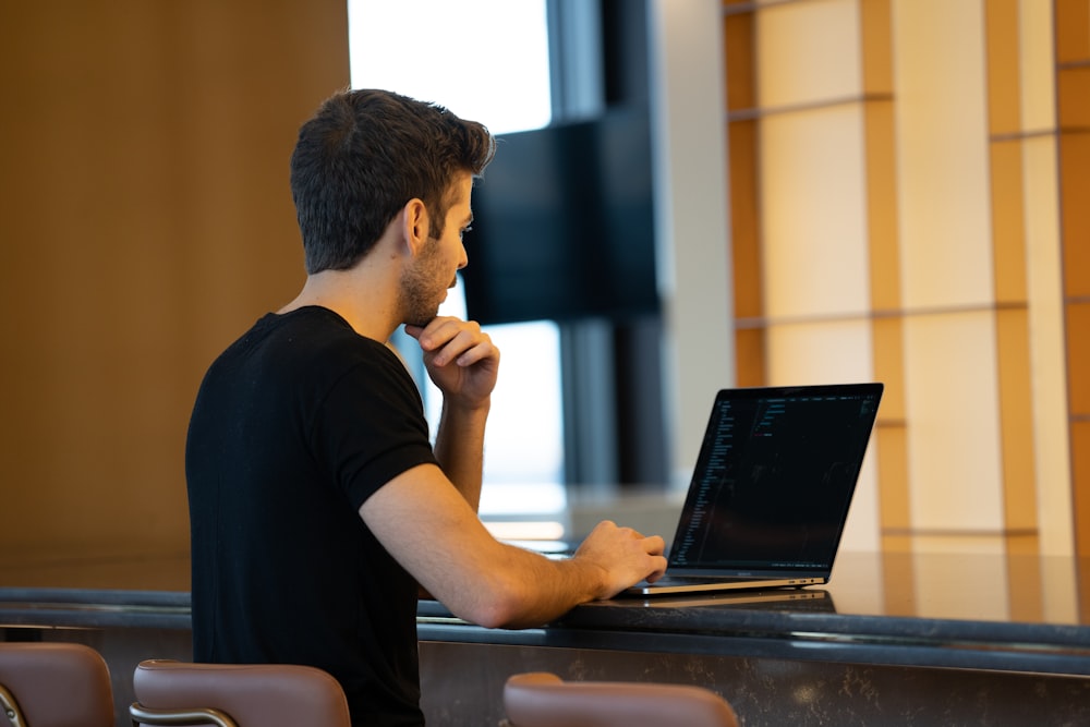 man in black crew neck t-shirt using black laptop computer