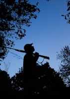 Close-up of a thermal scope displaying a coyote silhouette at dusk in eastern North Carolina woods.