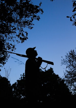 Close-up of a thermal scope displaying a coyote silhouette at dusk in eastern North Carolina woods.