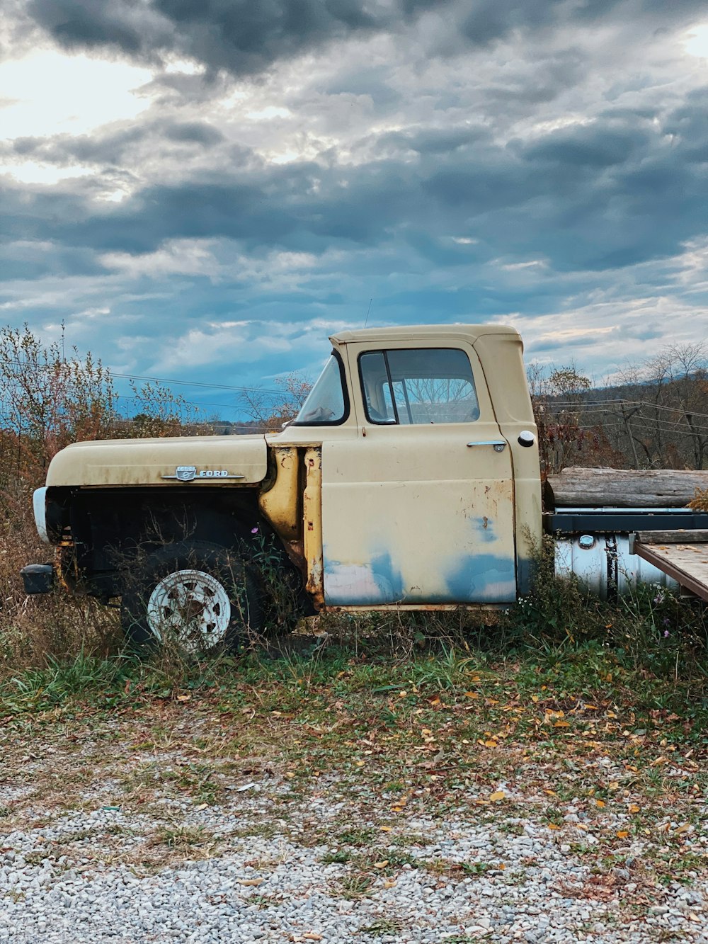 white single cab pickup truck on green grass field under white clouds and blue sky during