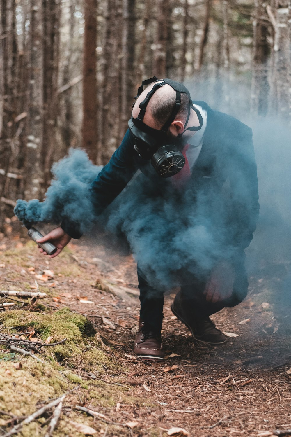 man in black jacket and black goggles standing on brown soil with white smoke during daytime