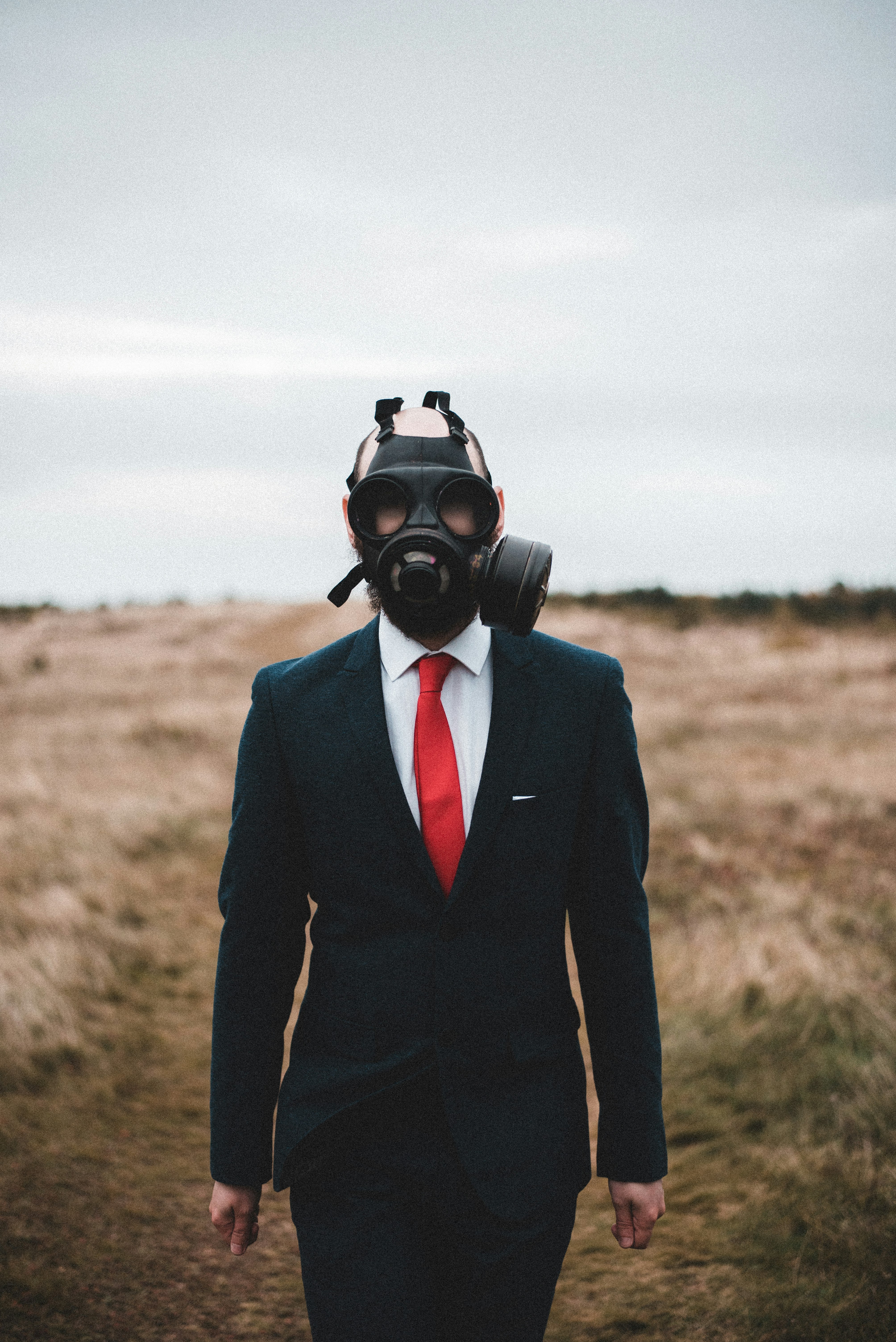 person in black suit wearing gas mask