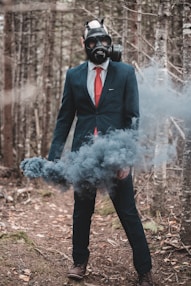 man in black suit standing on white smoke