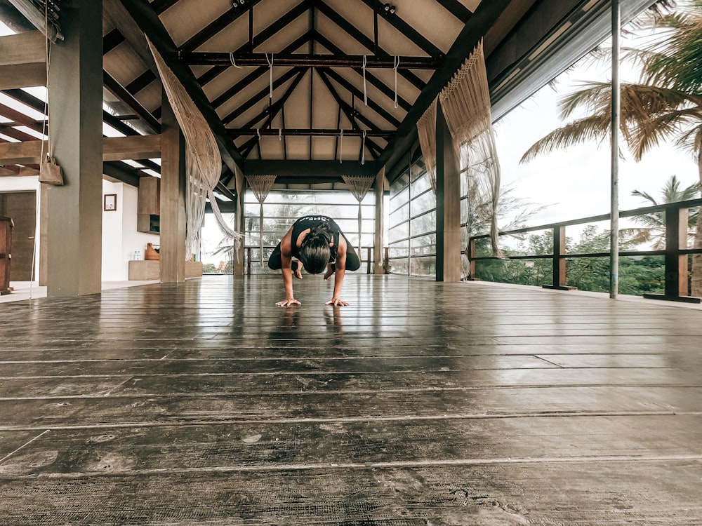 woman in black tank top and black shorts walking on wooden floor