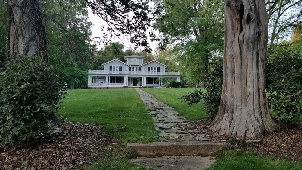 white and gray house near green trees during daytime