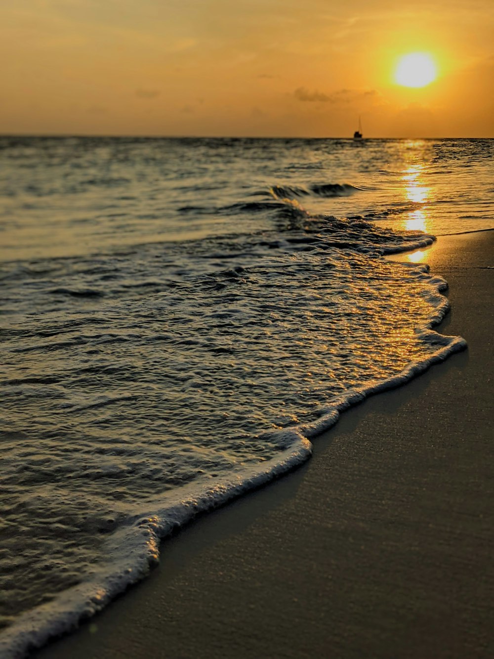 sea waves crashing on shore during sunset