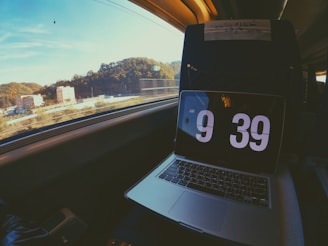 silver macbook pro on car