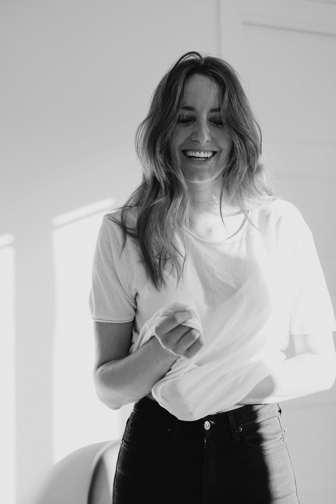 grayscale photo of woman in polo shirt smiling