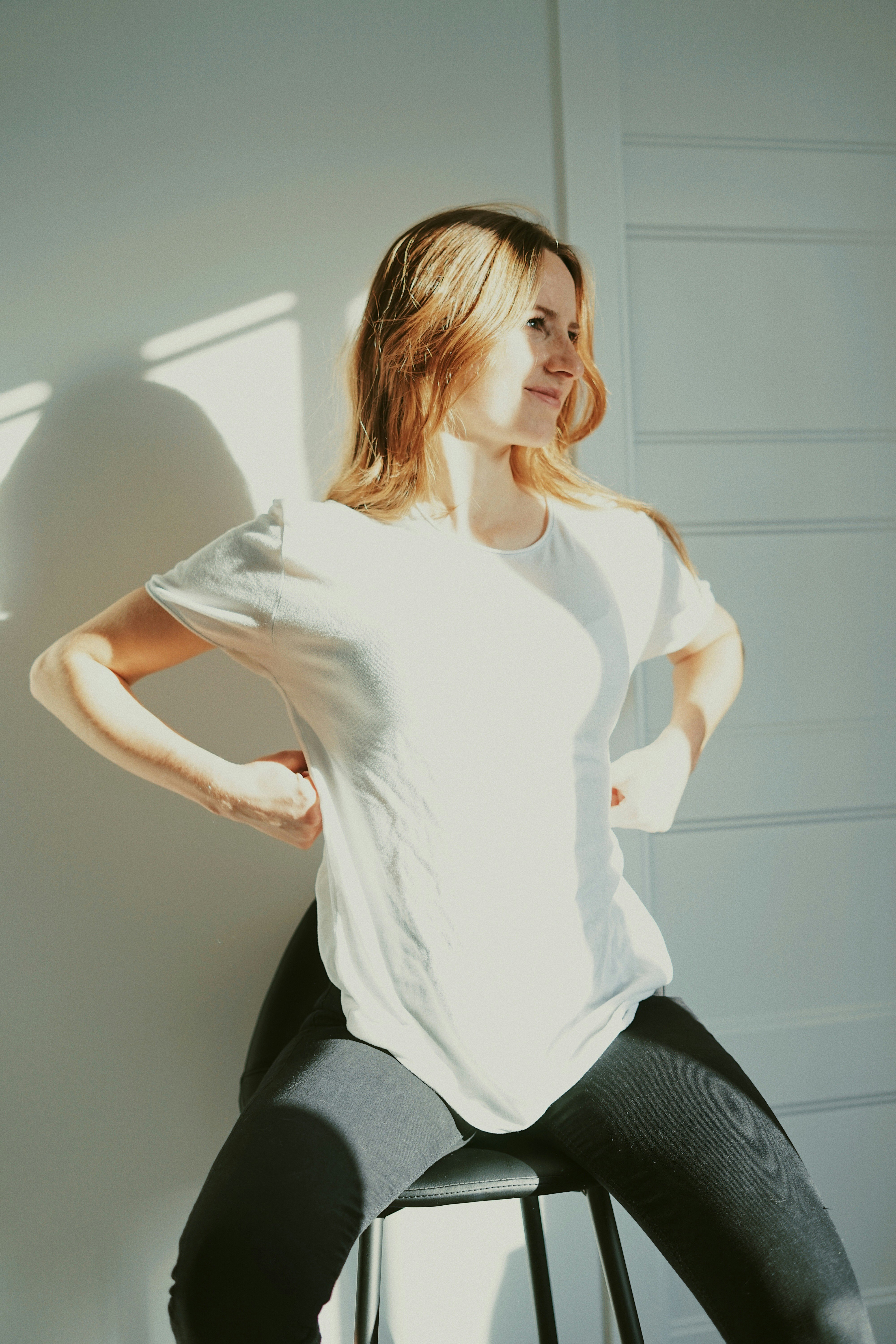 woman in white long sleeve shirt and black pants sitting on chair