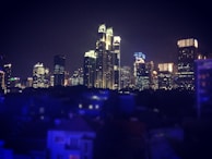 Nighttime view of a city skyline with buildings constructed by Dynamic Enterprises illuminated.