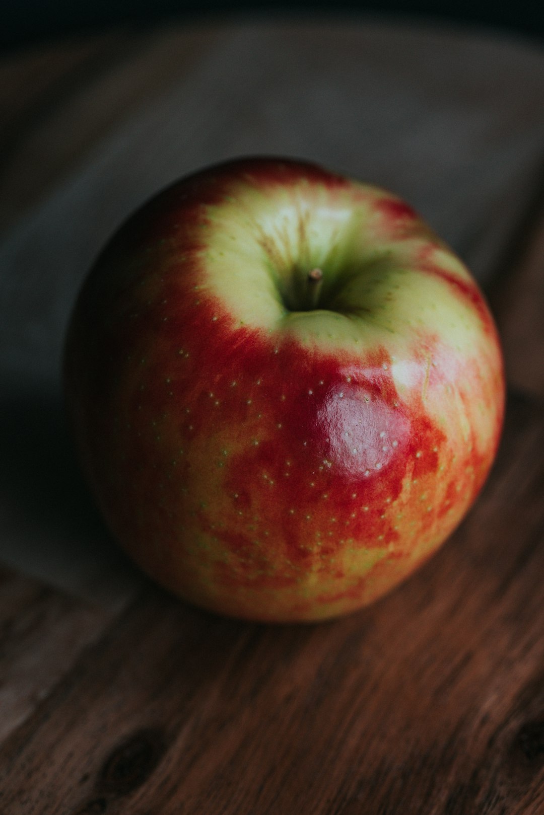 red apple fruit on brown wooden table