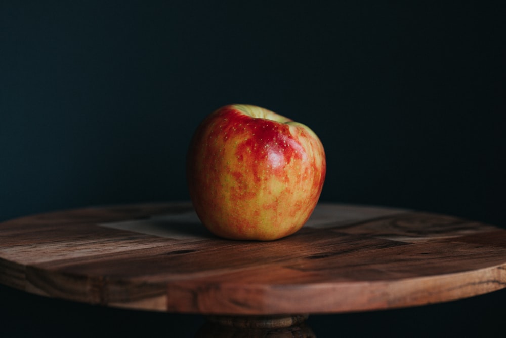 Manzana roja sobre mesa de madera marrón