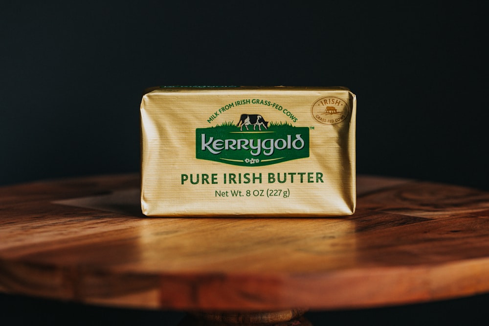 Ein Stück Butter sitzt auf einem Holztisch
