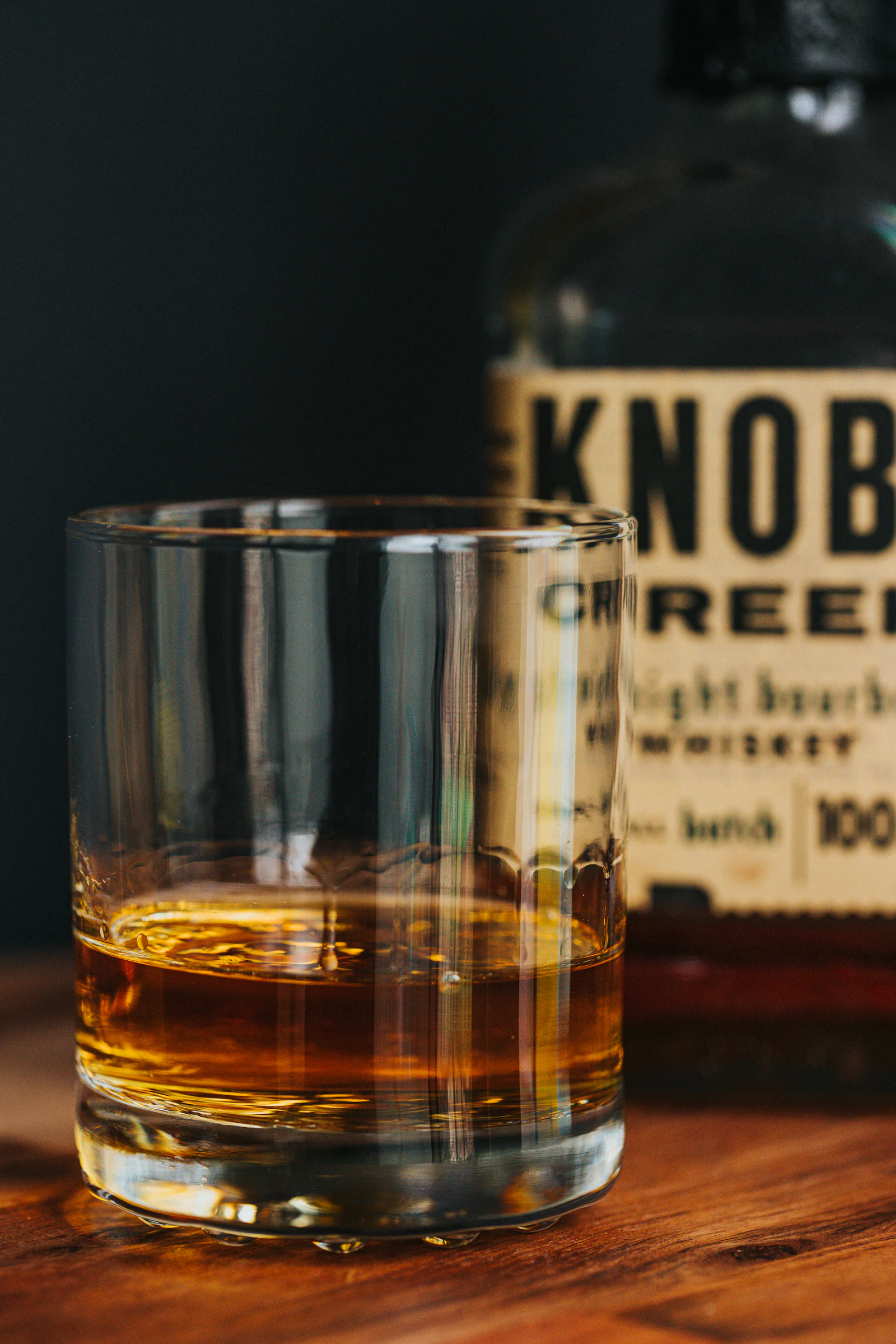A heavy tumbler of brown spirit, photographed close in low light.