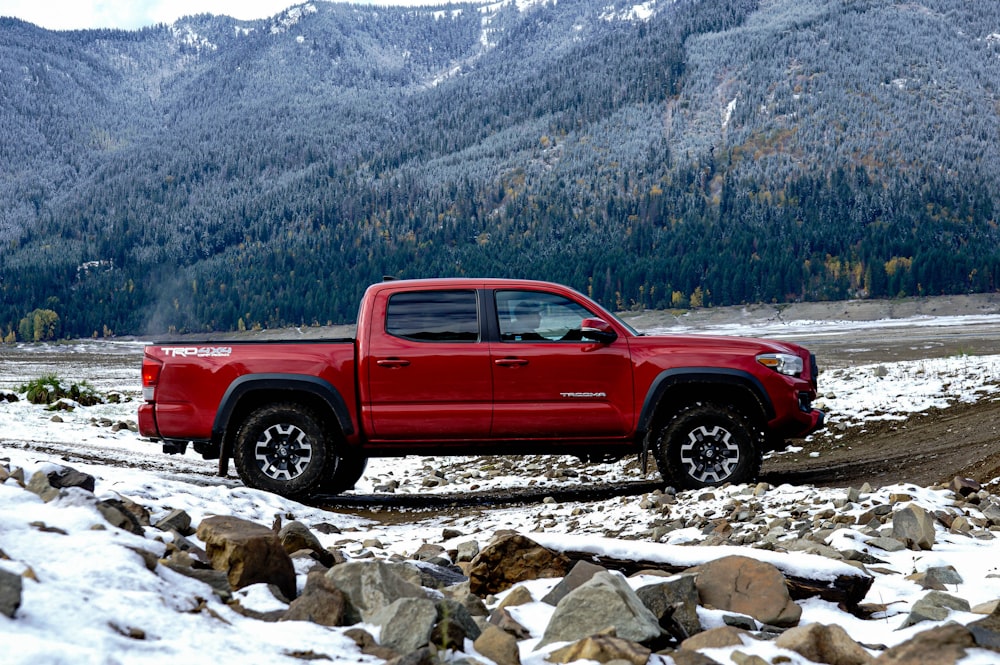 red crew cab pickup truck on rocky ground