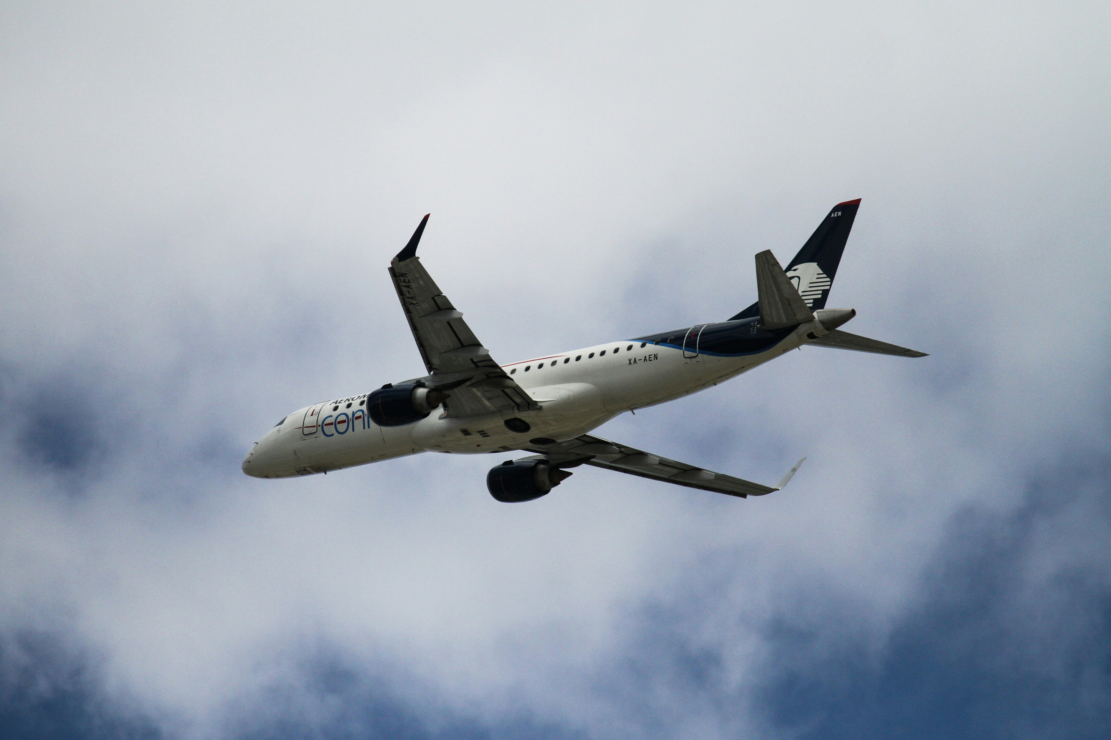 white and blue airplane under blue sky during daytime, Aeromexico’s embraer 190 airplane after takeoff