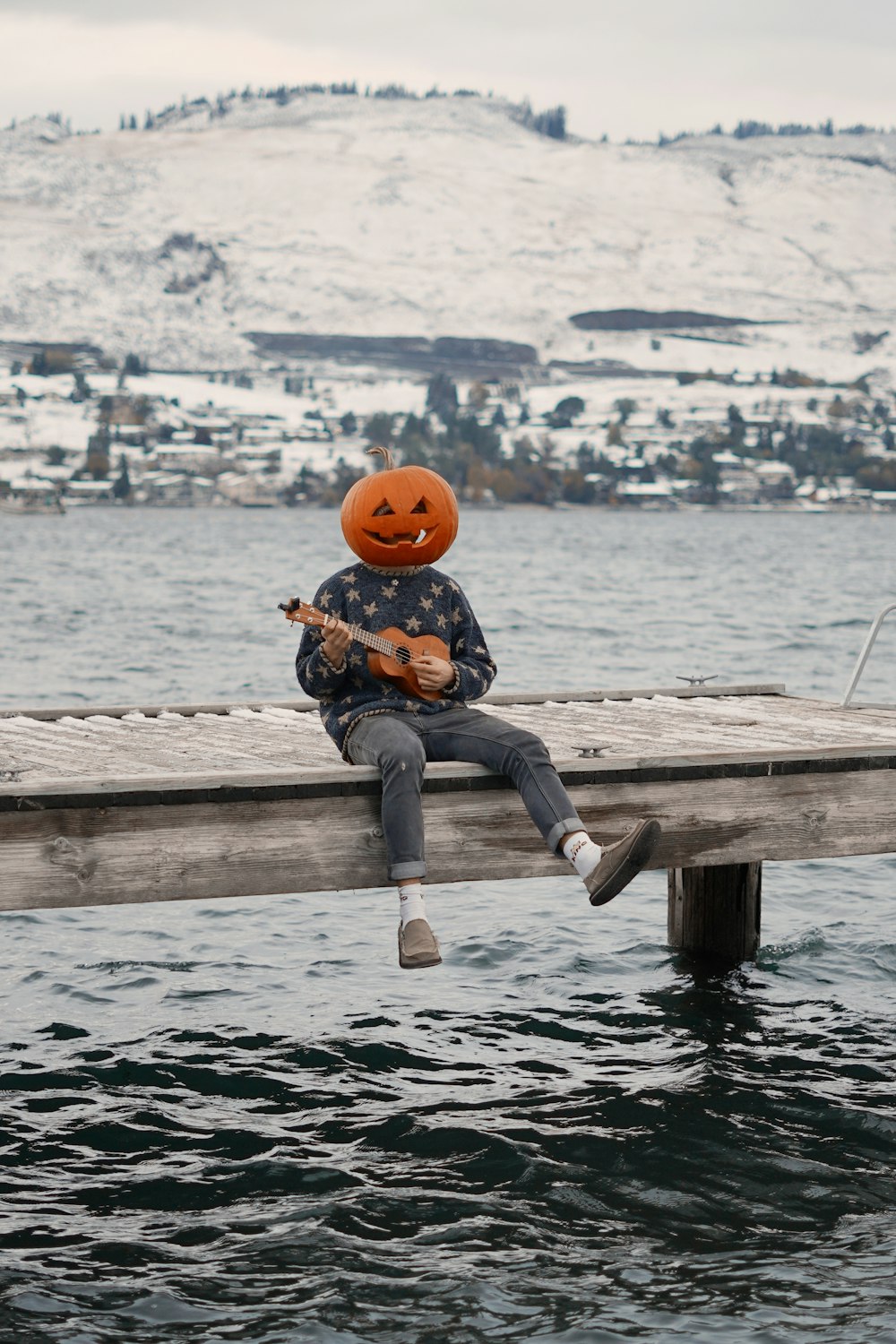 boy in blue denim jeans and orange helmet sitting on brown wooden dock during daytime