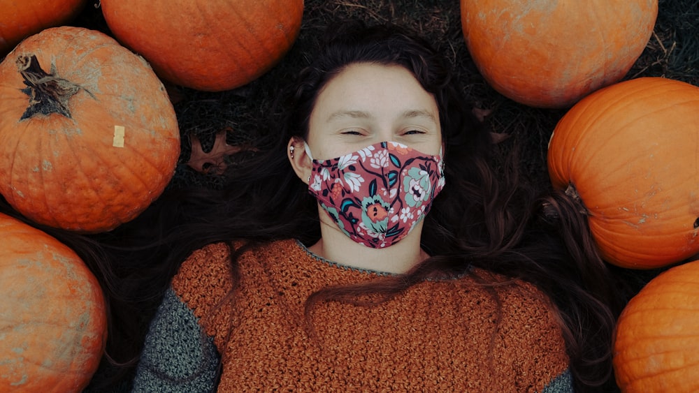 girl in red and black sweater with white mask