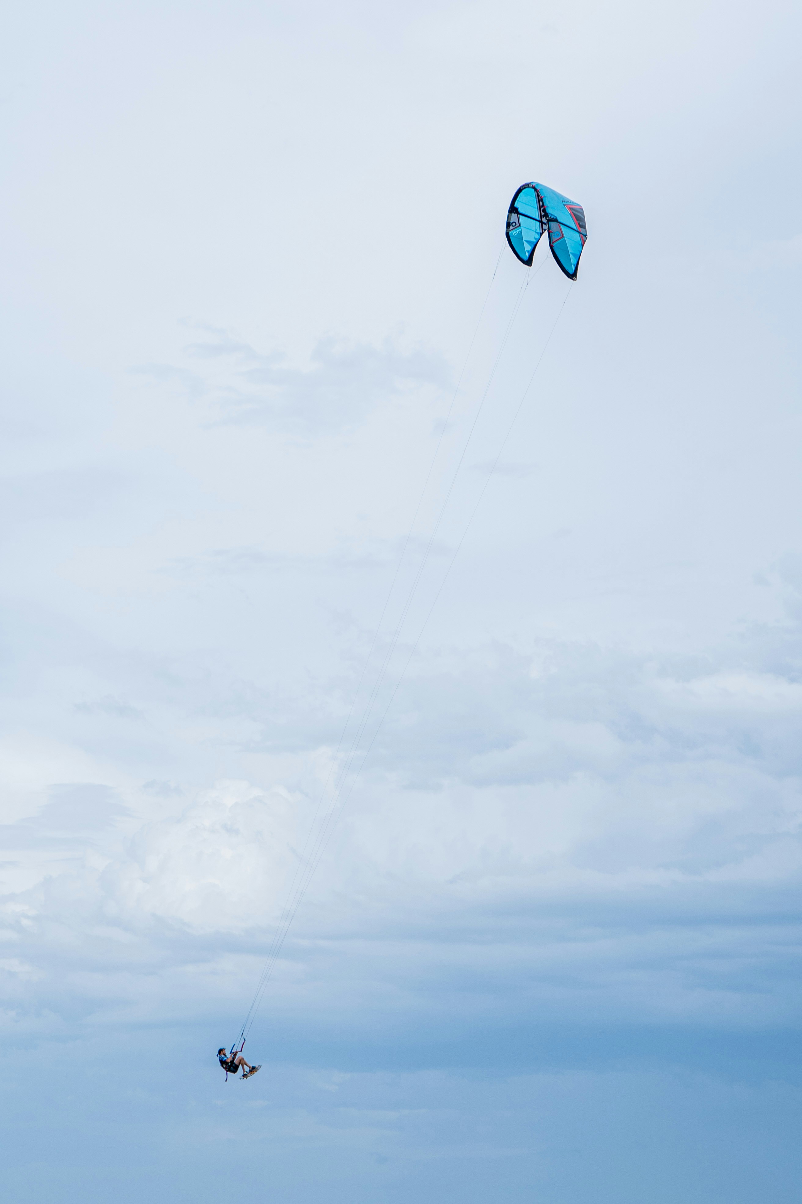 blue and yellow kite flying under white clouds during daytime