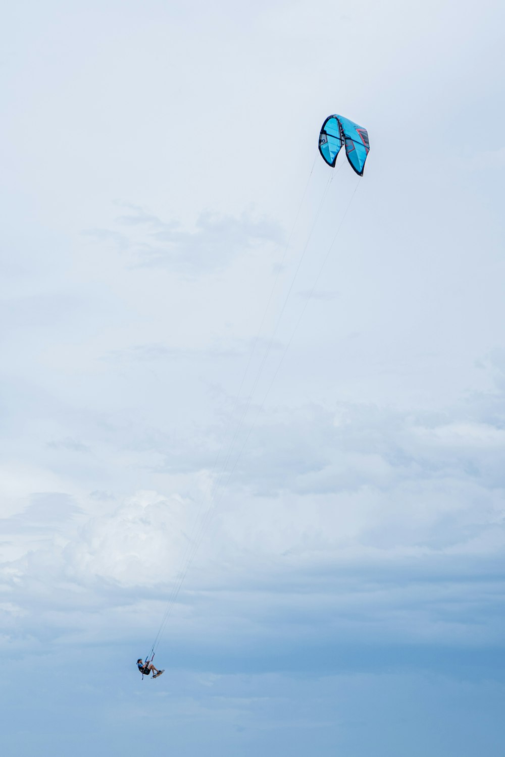 blue and yellow kite flying under white clouds during daytime