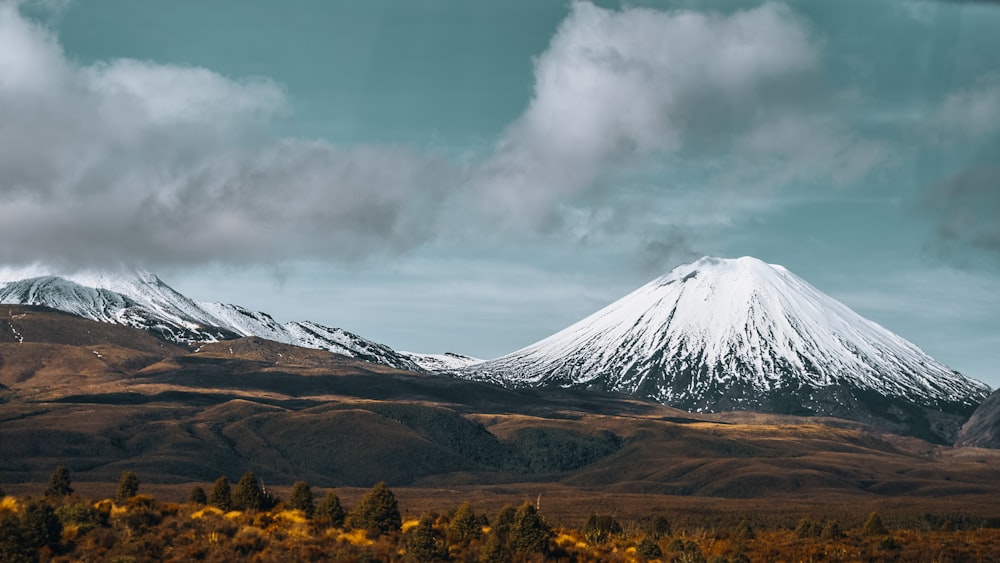 brown and white mountain under white clouds and blue sky during daytime