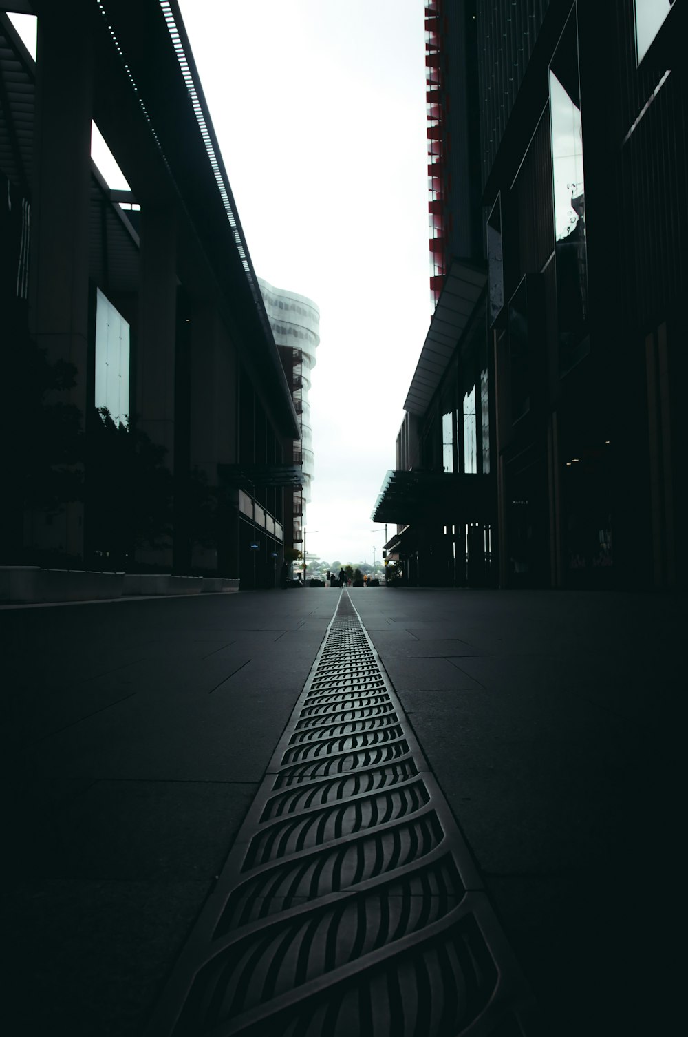 grayscale photo of empty street between buildings