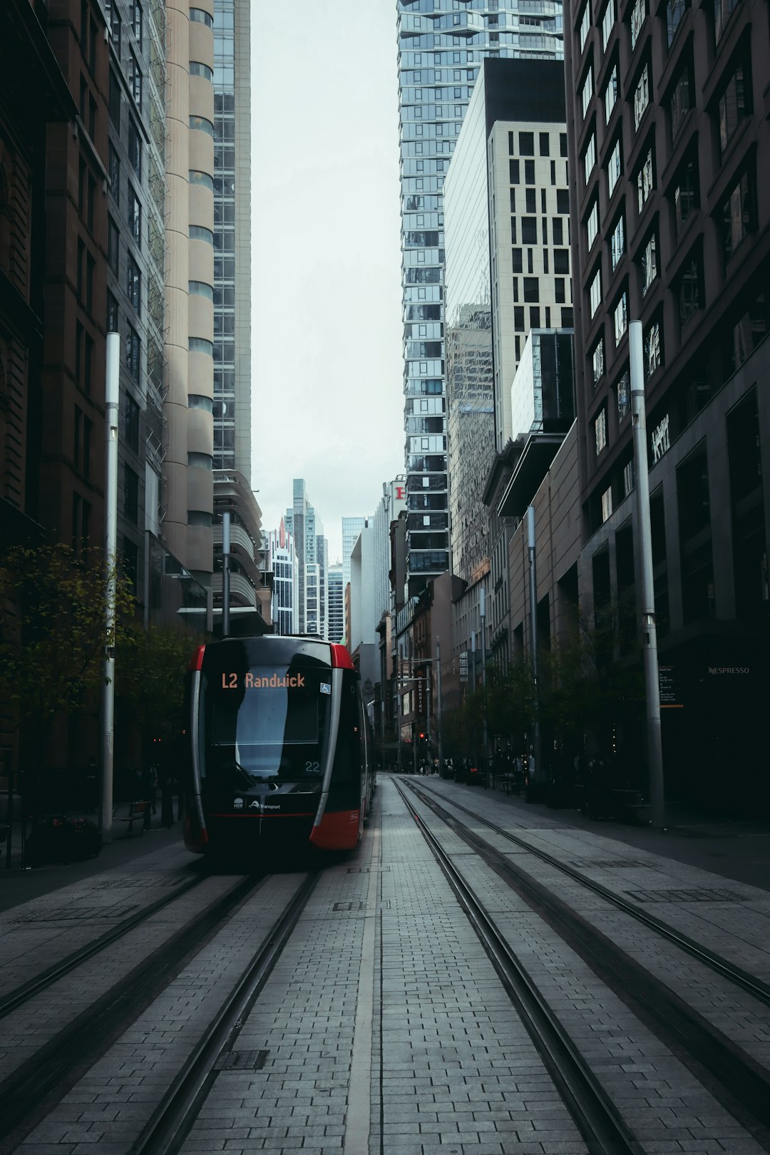black and white tram on road between high rise buildings during daytime