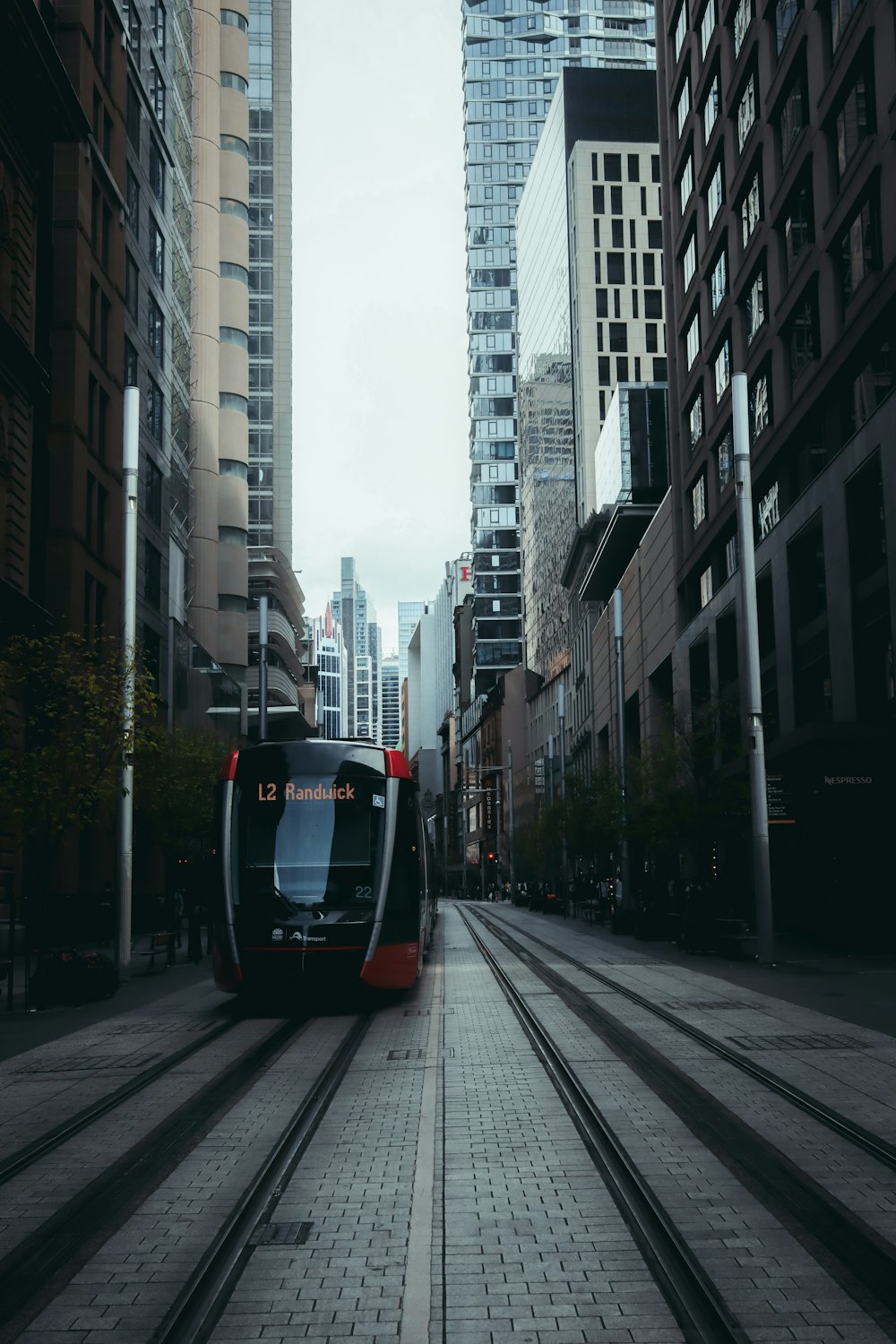 black and white tram on road between high rise buildings during daytime