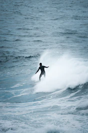 man surfing on sea waves during daytime