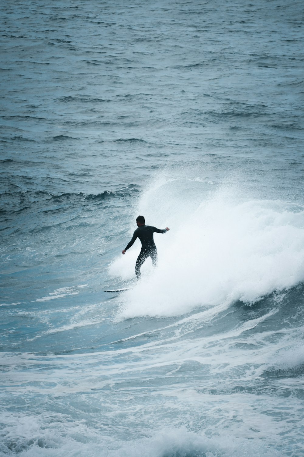 man surfing on sea waves during daytime