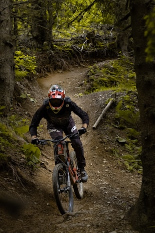 man in black jacket riding red and white mountain bike