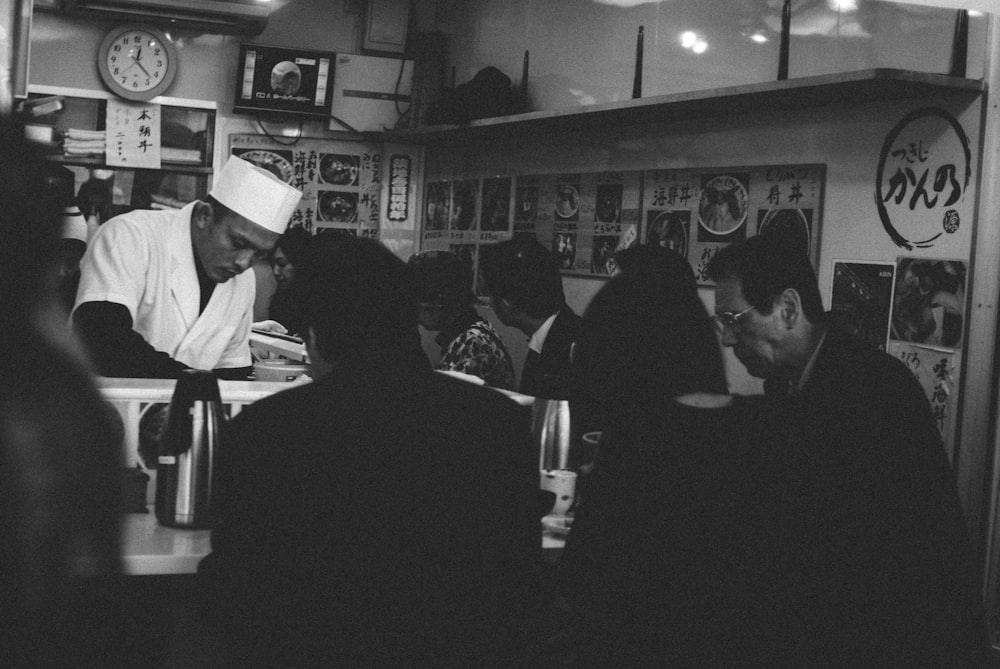 grayscale photo of people sitting on chairs