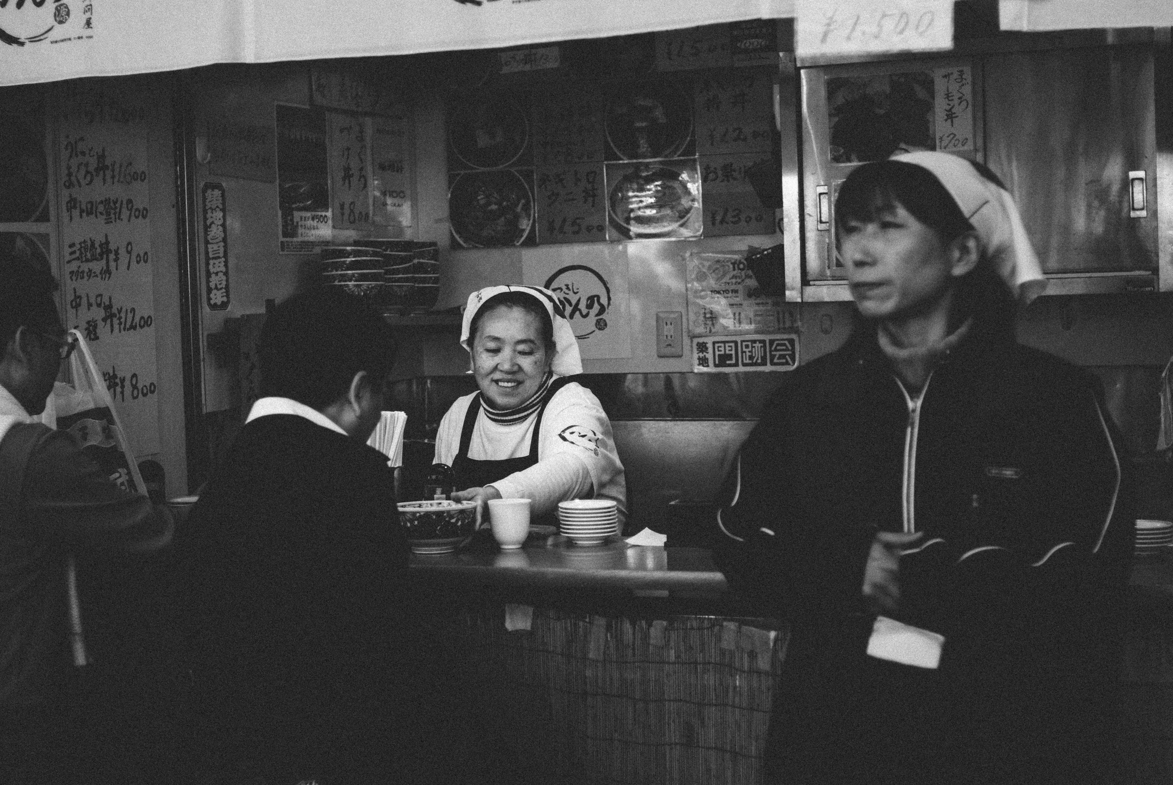 Busy Japanese izakaya with many people dining, blurred faces